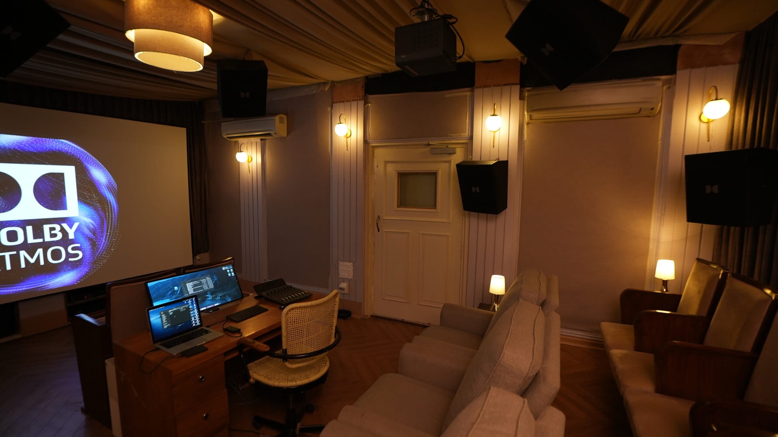 The Atmos mixstage from the back row, showing the desk, screen, surround speakers and projector