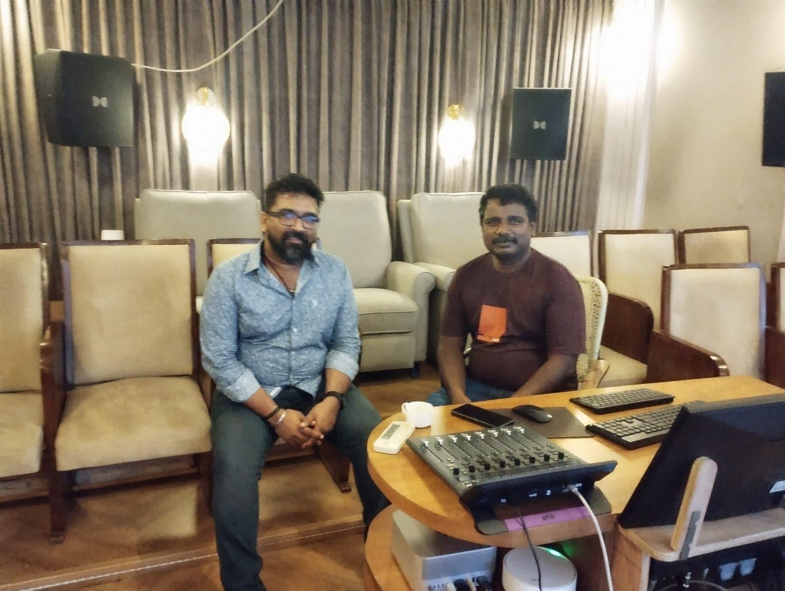 Two clients seated in the preview theatre beside the mixing desk